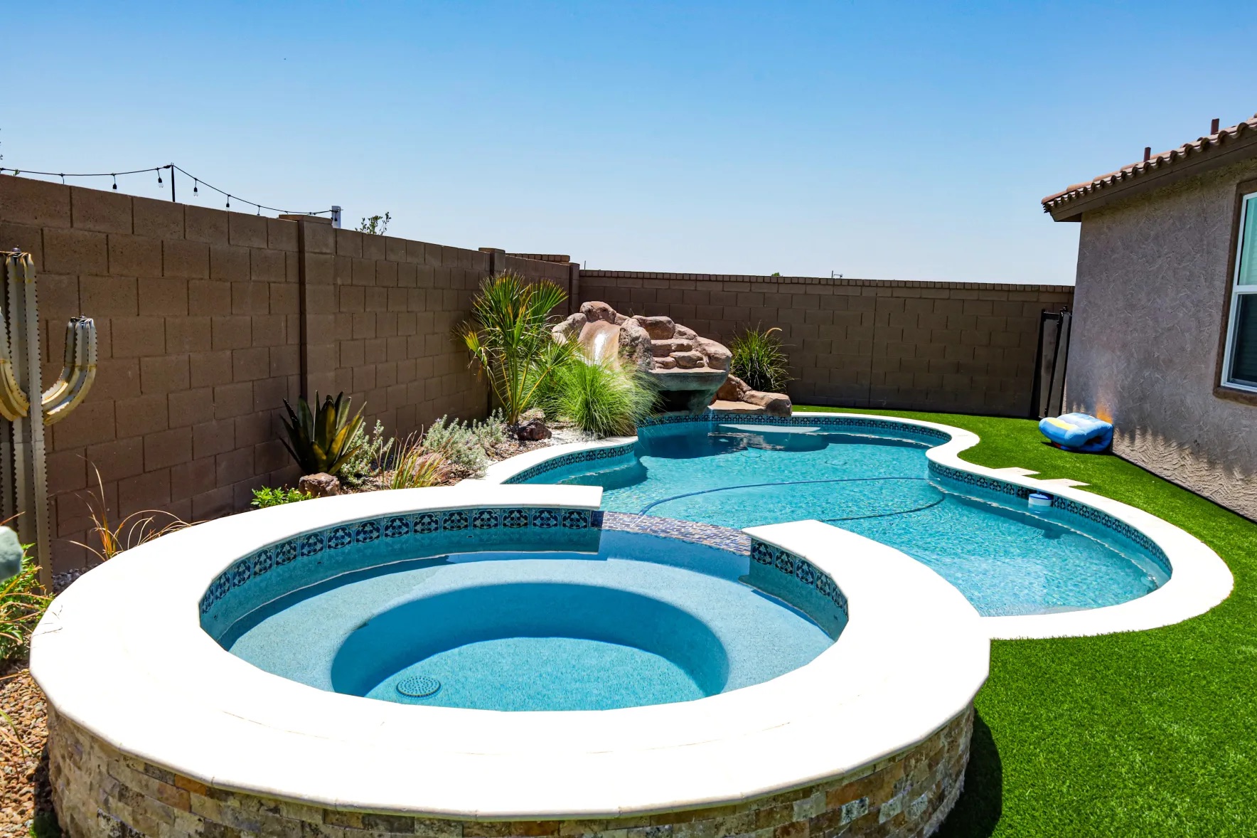 Renovated pool with natural boulder waterfall feature
